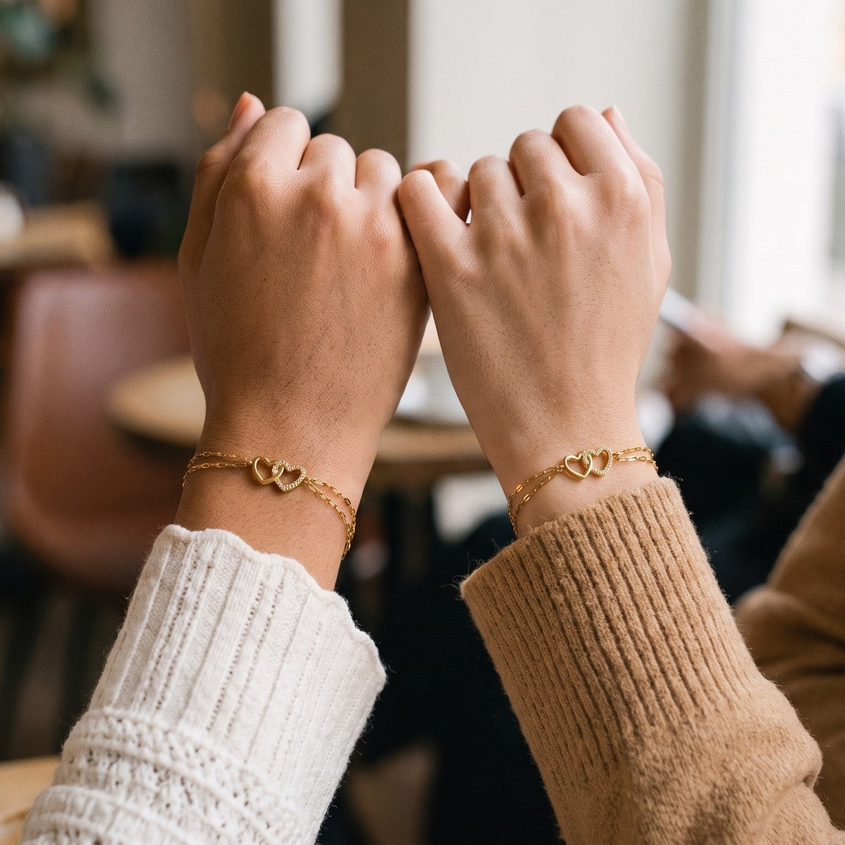 Two friends wearing matching Twin Hearts bracelets